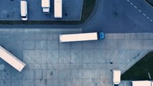 Aerial Top View Of A Of Semi-trailer Truck Traveling Through The Parking Lot Of The Warehouse/ Storage Building/ Loading Area