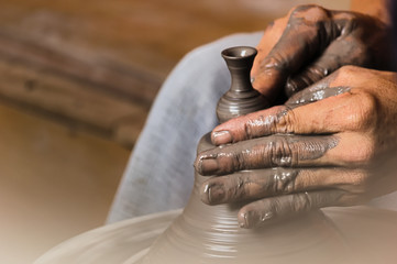 Ceramic potter is molding a vase.