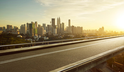 Wall Mural - Empty asphalt flyover  road with modern cityscape skyline , sunrise scene .