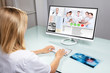 © Andrey Popov - Dentist Video Conferencing With Her Colleagues On Computer