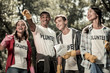 © Viacheslav Yakobchuk - Volunteer sign. Beaming funny students wearing white shirt with volunteer sign feeling responsible while cleaning forest