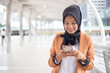 muslim businesswomen in hijab using smartphone in city.