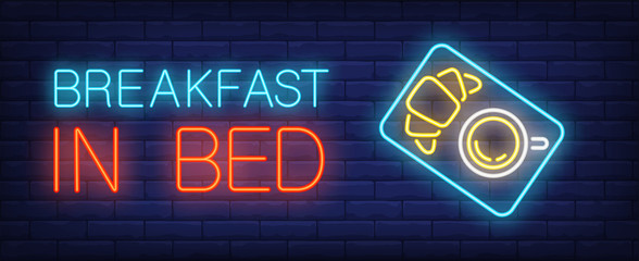 Breakfast in bed neon sign. Tray with coffee cup and croissant. Night bright advertisement. Vector illustration in neon style for hotel service, food delivery or cafe