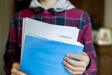 close up hands holding blue paper folder with documents, contract sheet f