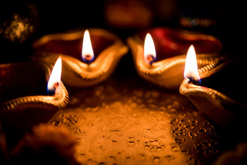 Beautiful diwali diyas at night with flowers, lighting series and gifts, moody background