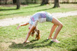© Cimermane - Little girl child doing exercises gymnastic outdoor in the park for fun at sunny day
