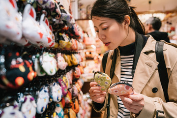 Wall Mural - a lovely female tourist choosing coin purses