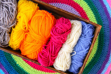 Knitted mat and colorful skeins of wollen yarn