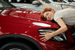 © alfa27 - Dreams come true today. Young emotive cute woman with amazed expression, embracing her new cargently at car show room. Husband bought her new car for b-day.