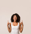 © Prostock-studio - Excited african-american woman pointing up, copy space