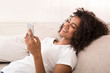 © Prostock-studio - African-american girl surfing in internet on smartphone