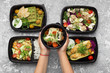 © Prostock-studio - Plastic containers with delicious food on gray background