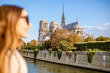 Cityscape view on the famous Notre-Dame cathedral on Seine river with woman face on the foreground in Paris, France. Focus on the background