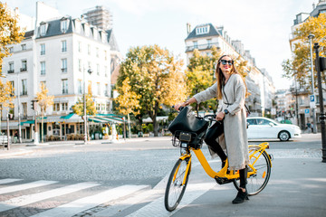 Wall Mural - Portrait of a young stylish woman with yellow bicycle on the street in Paris