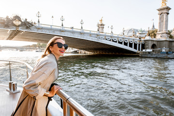 young woman enjoying beautiful landscape view on the riverside from the tourist ship during the suns