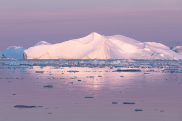 Wall Mural - magical and almost surreal alpen glow lighting up glacier in purple light during midnight sun. disko