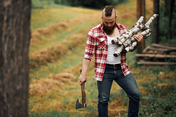 Wall Mural - Bearded mohawk Man with firewoods and with axe on shoulder