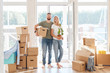 Happy young Couple Carrying Cardboard Boxes Into New Home On Moving Day