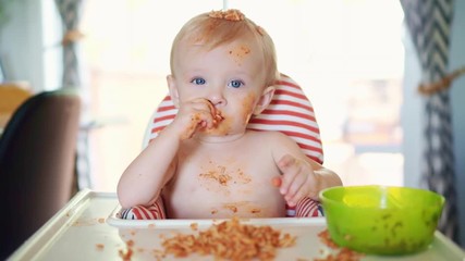 little baby eating spaghetti dinner and making a mess