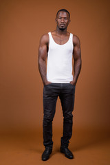 Handsome muscular African man against brown background