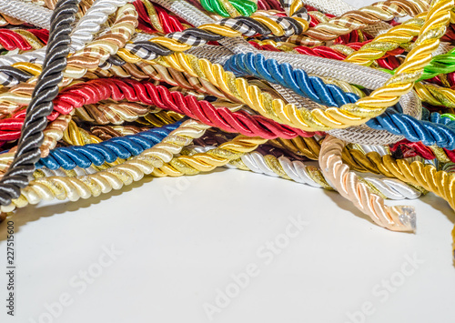 Fotografía Multi-colored braided decorative laces scattered in a mess