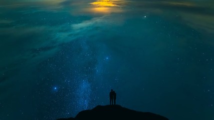 Wall Mural - The couple standing on mountain on the starry sky background. time lapse