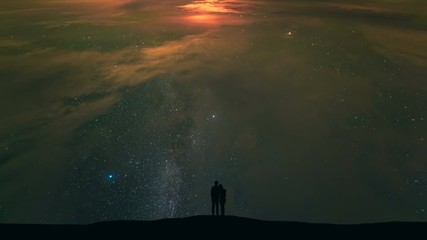 Wall Mural - The man and a woman standing on cloud stream with stars background. time lapse
