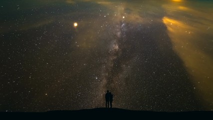 Wall Mural - The man and a woman standing on a strarry sky background. time lapse