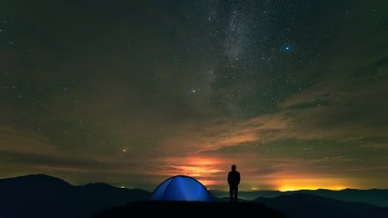 Wall Mural - The man near camping tent standing on a mountain with a cloud stream. time lapse