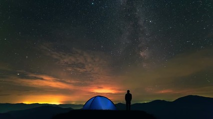 Wall Mural - The man near camping tent standing on a mountain with a cloud flow. time lapse