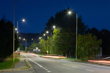 night empty road with modern LED street lights, entrance to a small town