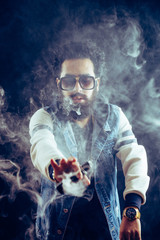 Wall Mural - Smoking vape. vaping man holding a mod. Vape Rings. A man launches a ring of smoke. Tricks with smoke.