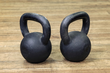 two heavy kettlebell black on wooden background