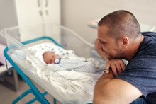 Tender Moment Between A Father And His Newborn Baby