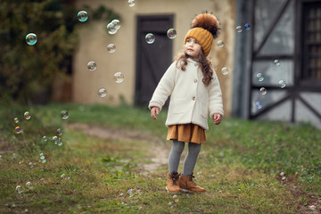 girl playing with soap bubbles outdoors