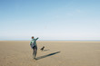 © liamgrant/Stocksy - Male playing ball with his dog on a vast empty beach. Holkham, N