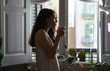 © Bonninstudio/Stocksy - Young woman having a tea on morning.