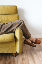Female Wearing Wool Pants Resting On Vintage Yellow Sofa