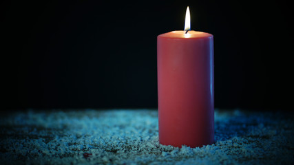 Wall Mural - Red Christmas candle glows in dark background