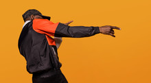 Stylish Sporty Man Dancing Over A Yellow Background
