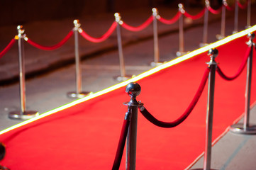 Long red carpet between rope barriers on entrance.