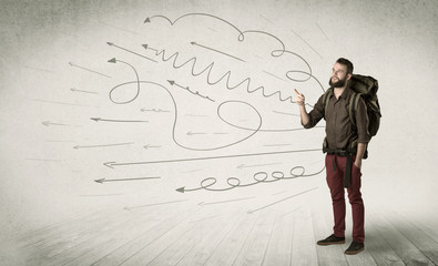 Wall Mural - Handsome young man standing with a backpack on his back and scribbles in the background