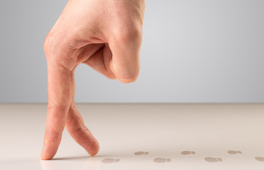 Female fingers walking with footsteps behind them 