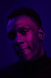 © leandrocrespi/Stocksy - African American man portrait under blue and purple lights - Ultraviolet