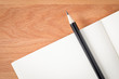 © korkeng - Top view open notebook white pages with pencil on wood texture desk background