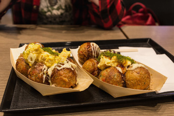 Delicious meal: two portions of meatballs or cheese balls on a paper plates