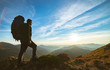 © realstock1 - The man standing with a camping backpack on the rock with a picturesque sunset