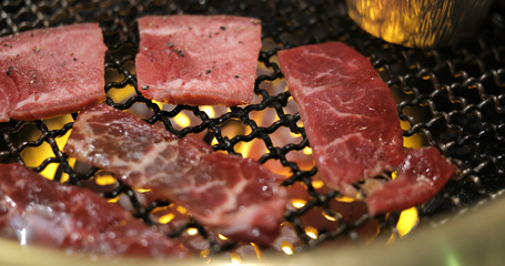 Beef meat on metal net in restaurant