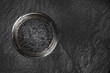 Black fish roe in a jar, shot from the top on a black background with a place for text