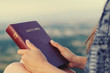 © PhotoGranary - Christian worship and praise. A young woman is holding the bible in her hand.